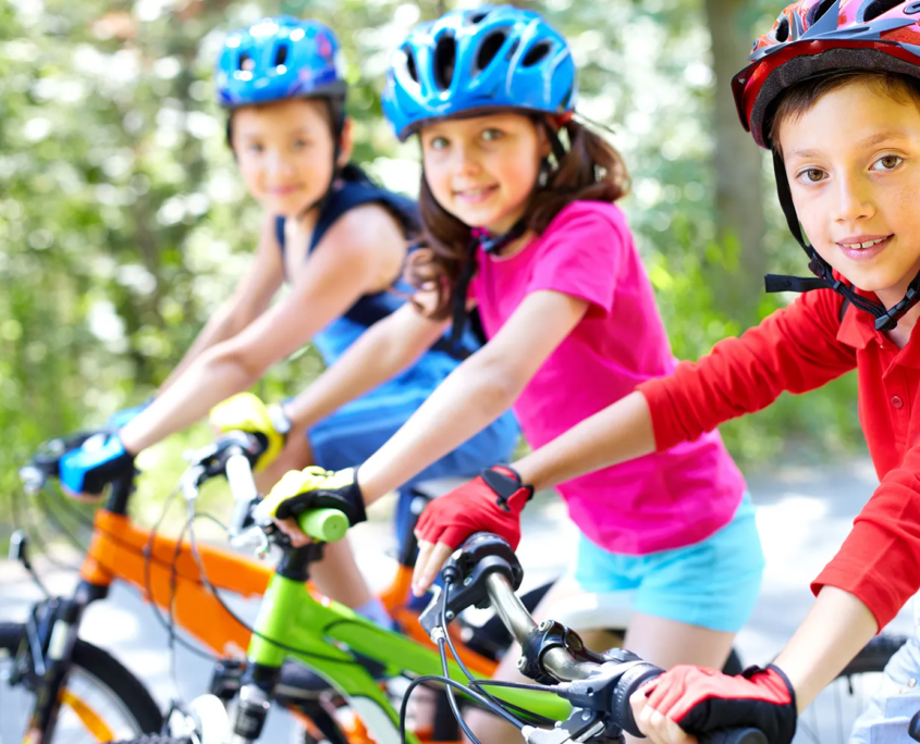 Drei Kinder sitzen auf ihren Fahrrädern