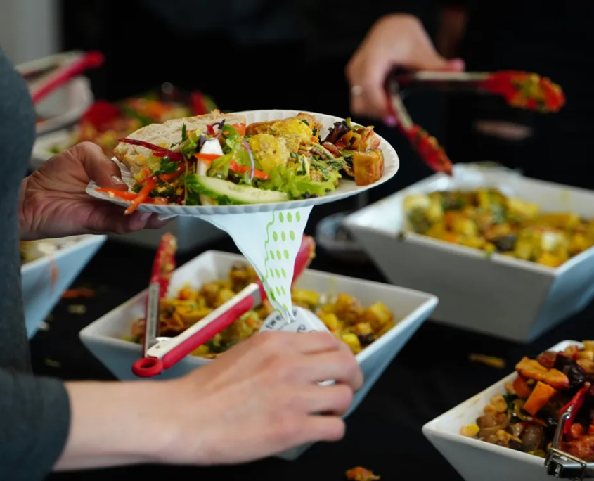 Menschen holen sich verschiedene Speisen am Buffet.