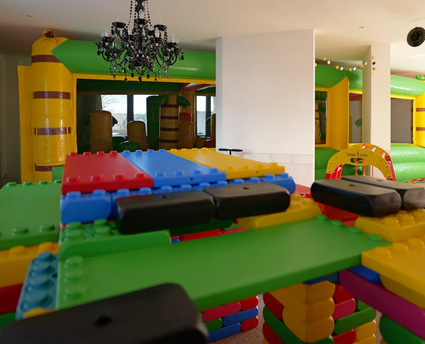 Indoorspielplatz mit XXL-Bausteinen und Hüpfburg im Hintergrund