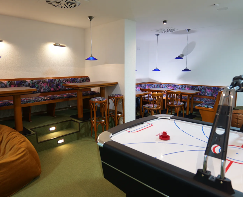Teenieklub mit Airhockeytisch und Sitzgruppen