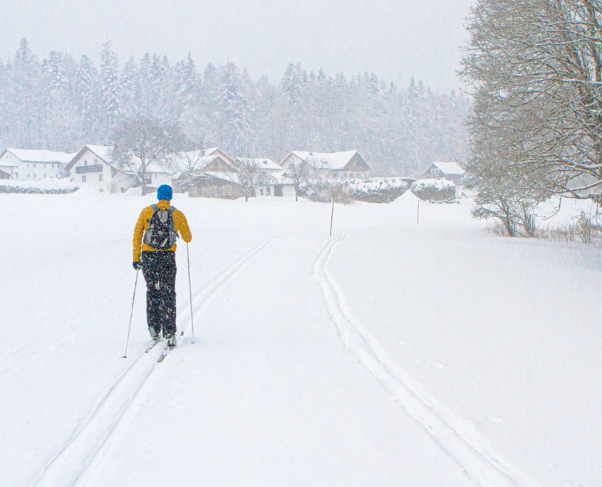 Mann fährt durch Winterlandschaft auf Langlaufski