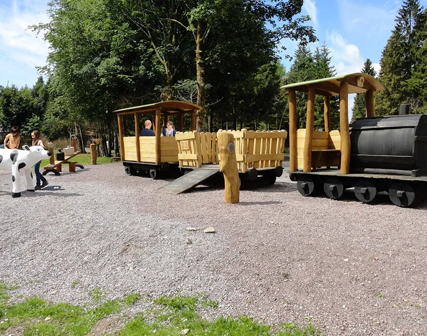 Spielplatz mit Holzeisenbahn und Holzkuh